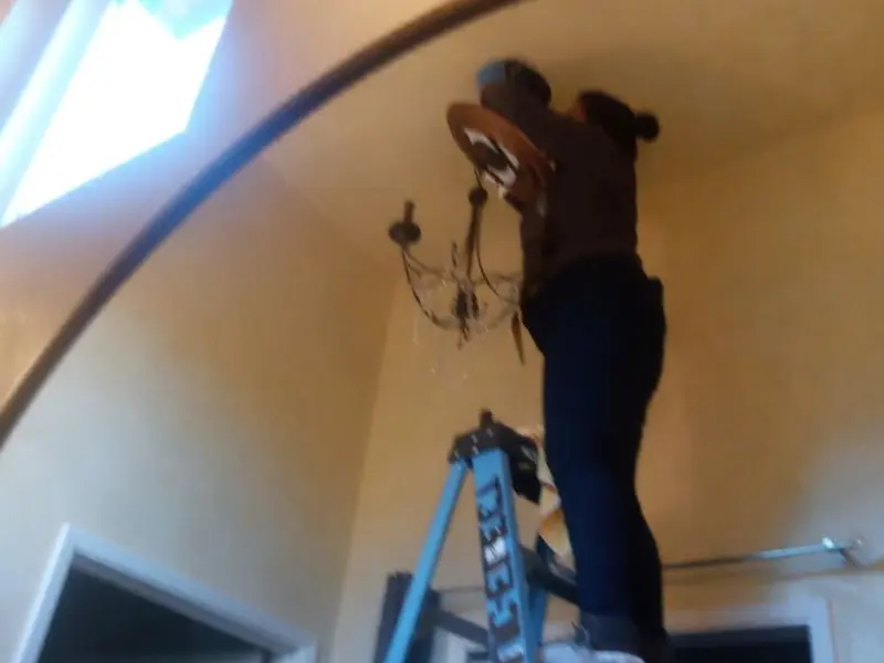 Electrician installing a chandelier in a Spring Valley Village residence